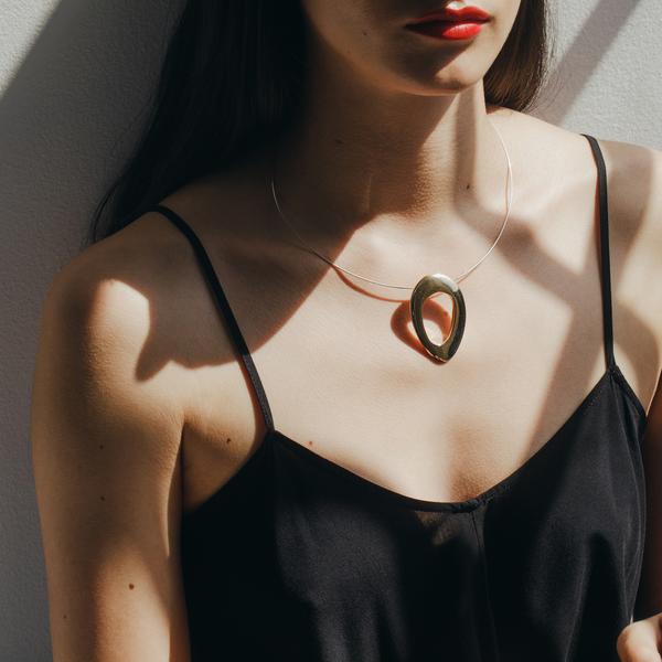 polished bronze oval pendant on model
